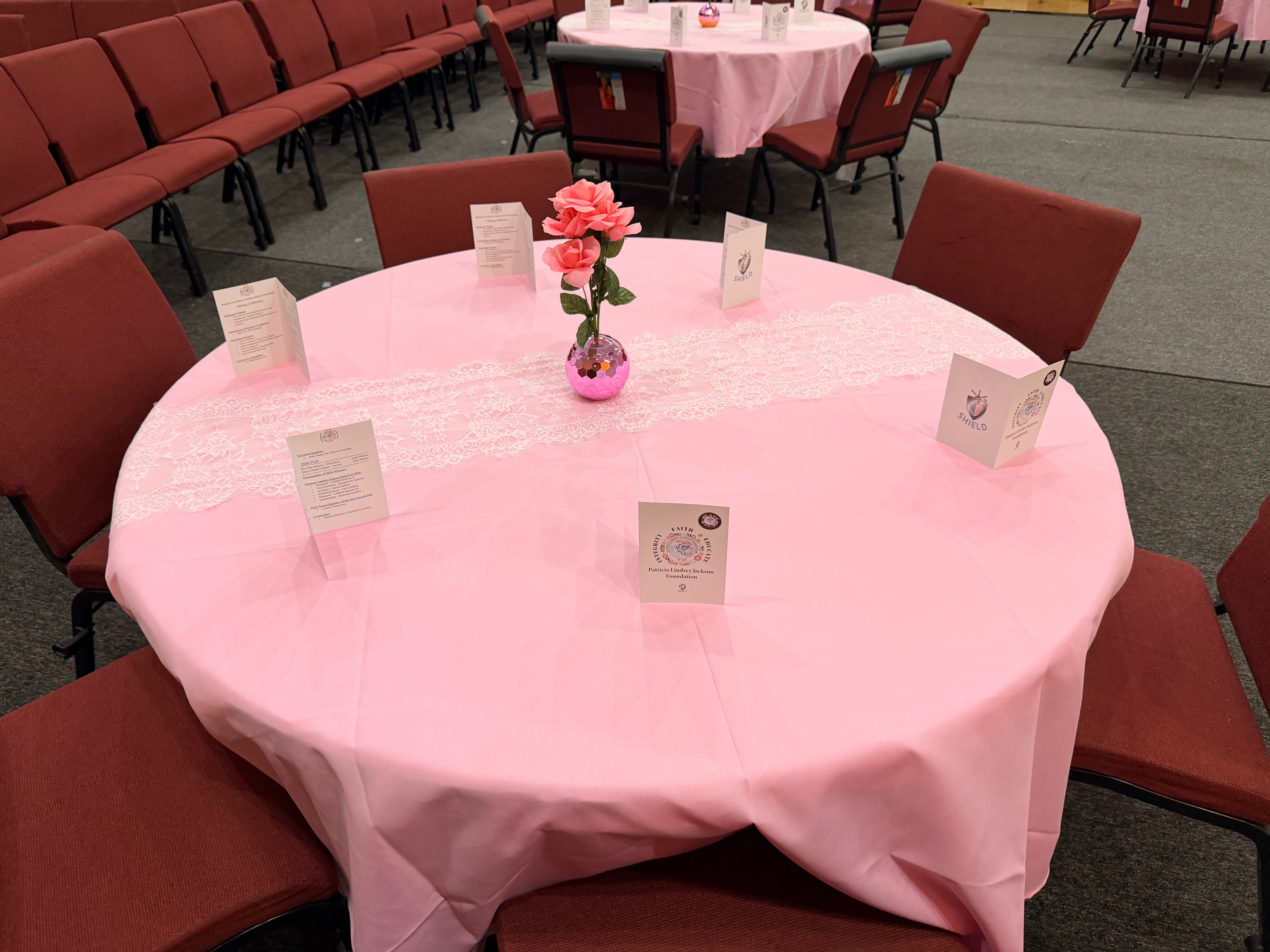 Pink table setting with conference programs and flowers